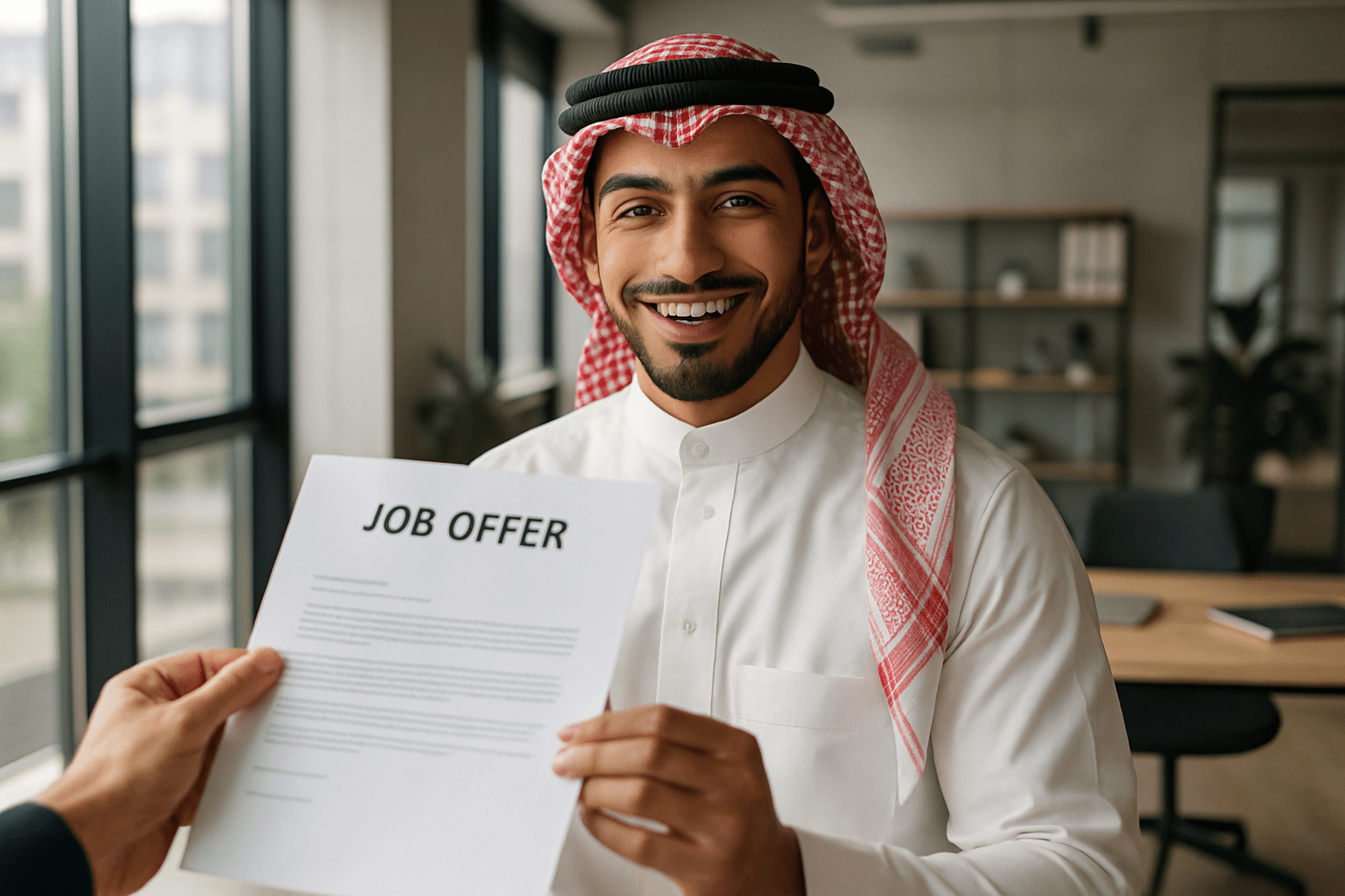 شاب سعودي يتسلم عرض عمل مكتوب بعد اجتياز المقابلة بنجاح.